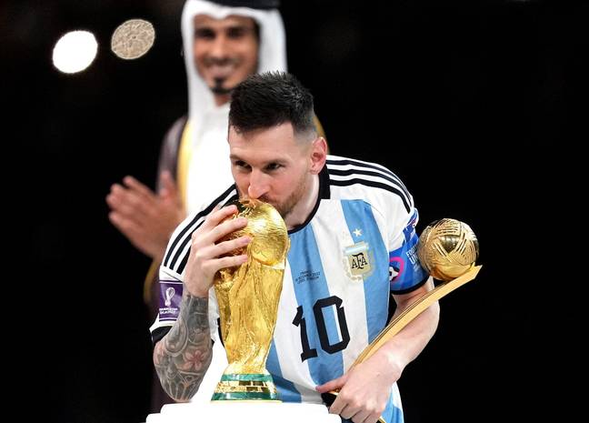 阿根廷的莱昂内尔·梅西（Lionel Messi）亲吻了FIFA世界杯奖杯，同时在卡塔尔（Lusail Stadium）举行的FIFA世界杯决赛中加入了加时赛后，在罚球大战后拿下金球奖杯。信用：PA图像 / Alamy