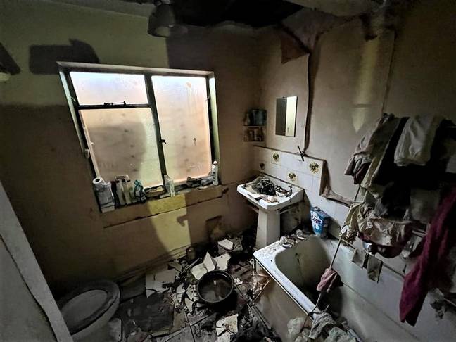 浴室里到处都是砸碎的瓷砖和一堆衣服。信用：SWNS