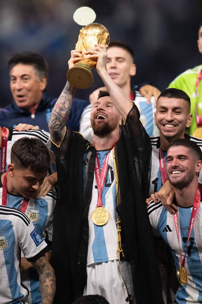 莱昂内尔·梅西（Lionel Messi）在他的比什特（Bisht）举起世界杯奖杯。图片来源：Abaca Press/Alamy