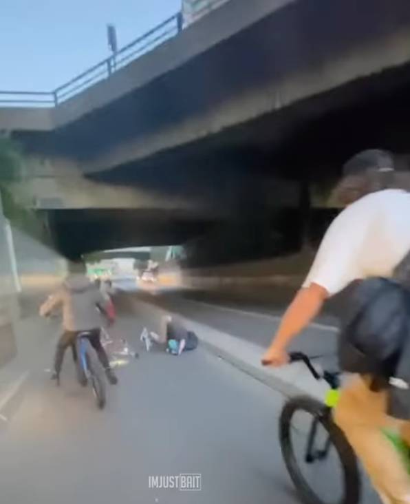 车轮骑手设法保持直立，但另一名骑自行车的人跌倒在地。学分： @imjustbait/ instagram