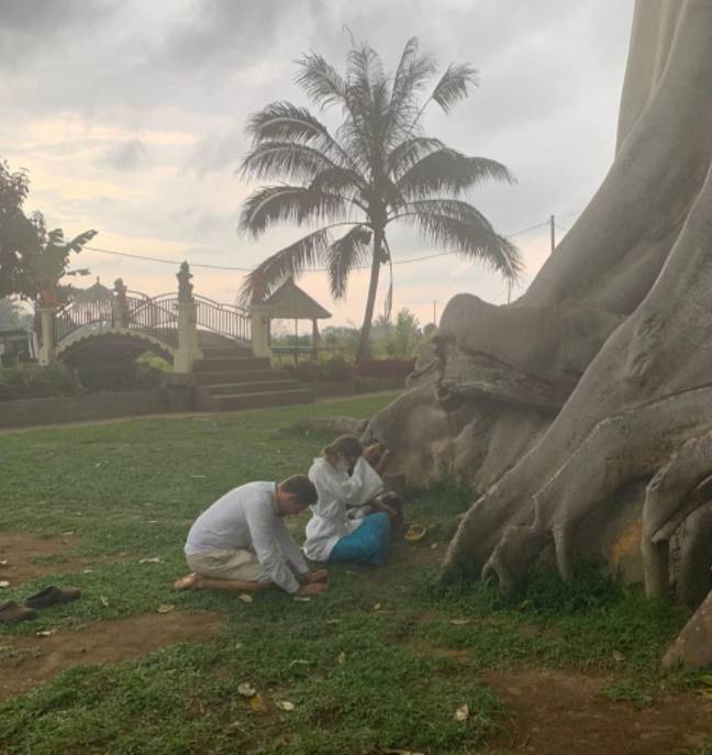 阿丽娜（Alina）在一段录像带上向她赤裸裸地摆在巴厘岛（Bali）神圣的一棵古老树上，道歉。学分： @alina_yogi/news必威杯足球flash）