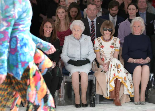女王右边有凯利（Kelly），安娜·温图尔（Anna Wintour）坐在他们之间。信用：PA图像 / Alamy Stock Photo