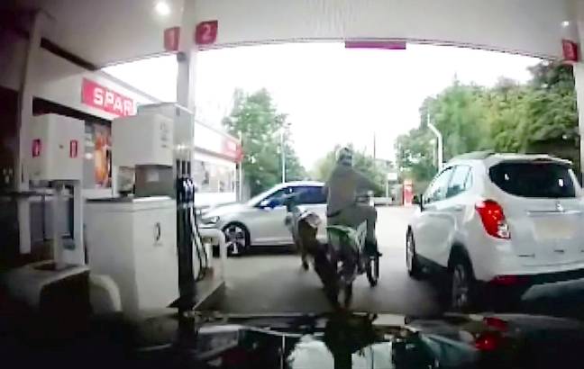 发现骑自行车的人后，警察在未标记的汽车上驶向汽油站。信用：SWNS