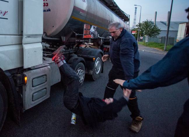 一名卡车司机被愤怒地从他的油轮上拉下了一名抗议者。学分：LNP