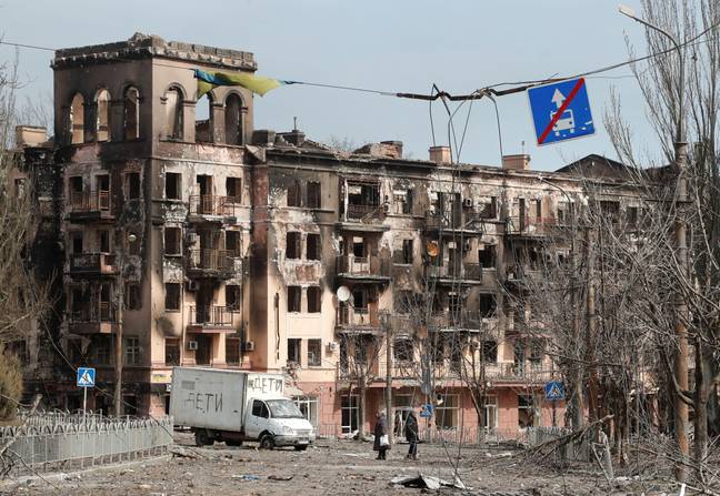 当地人沿着一条街道沿着一条街道行走，旁边的一座建筑物在南部港口城市玛丽波尔（Mariupol）的乌克兰 - 俄罗斯冲突中遭到破坏。学分：路透社 /阿拉米股票照片