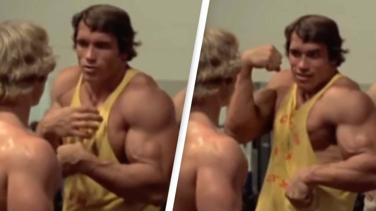 Arnold Schwarzenegger pumping up arms in his retro UAB t-shirt.