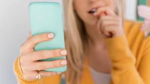 女人向使用小指持有智能手机的人分享警告