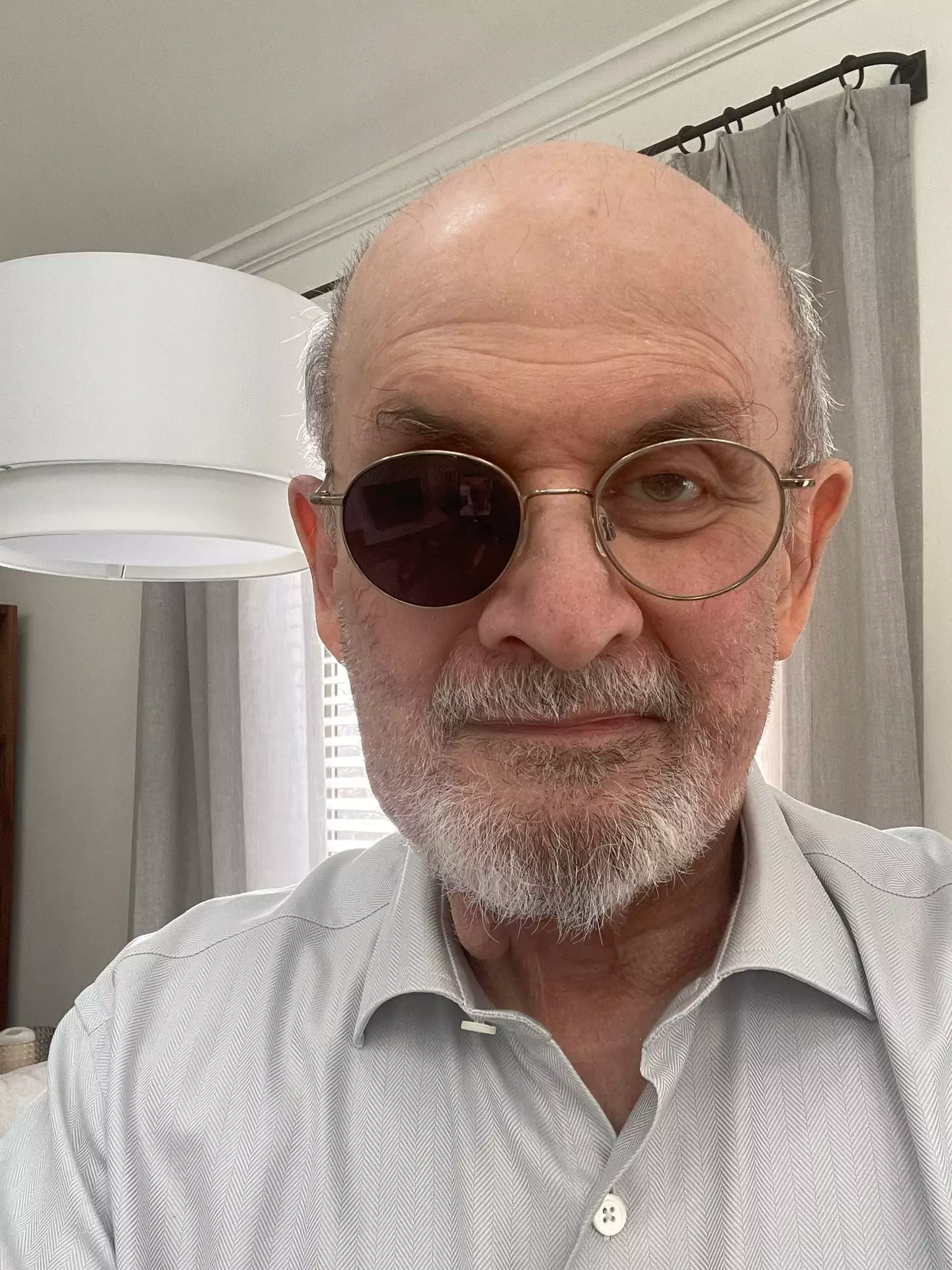 Sir Salman Rushdie has shared his first picture since being seriously injured in a horrific assassination attempt.