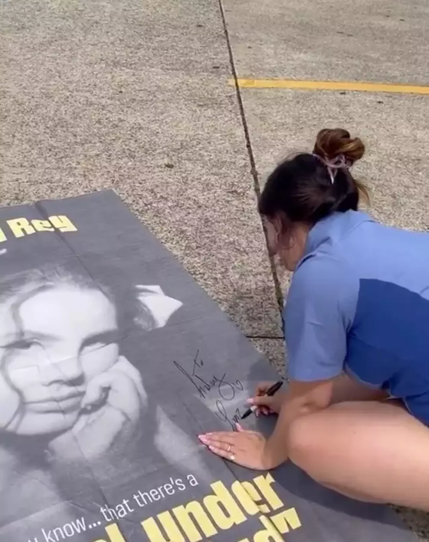 The singer stopped to sign a fan's poster.