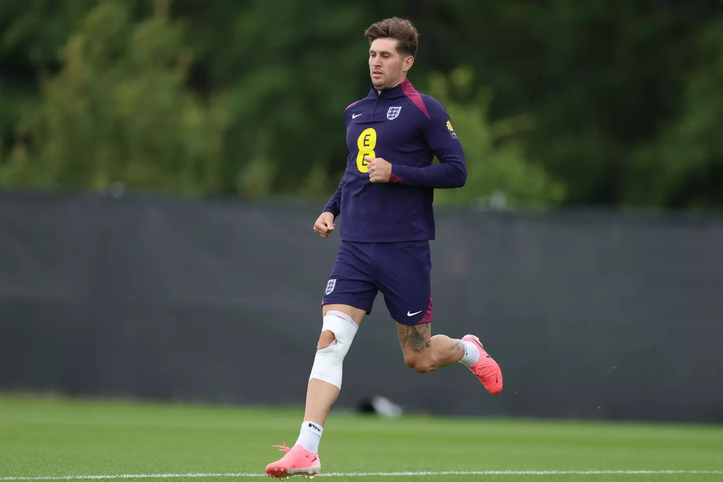 John Stones trains with heavy strapping on his right knee. Image: Getty  