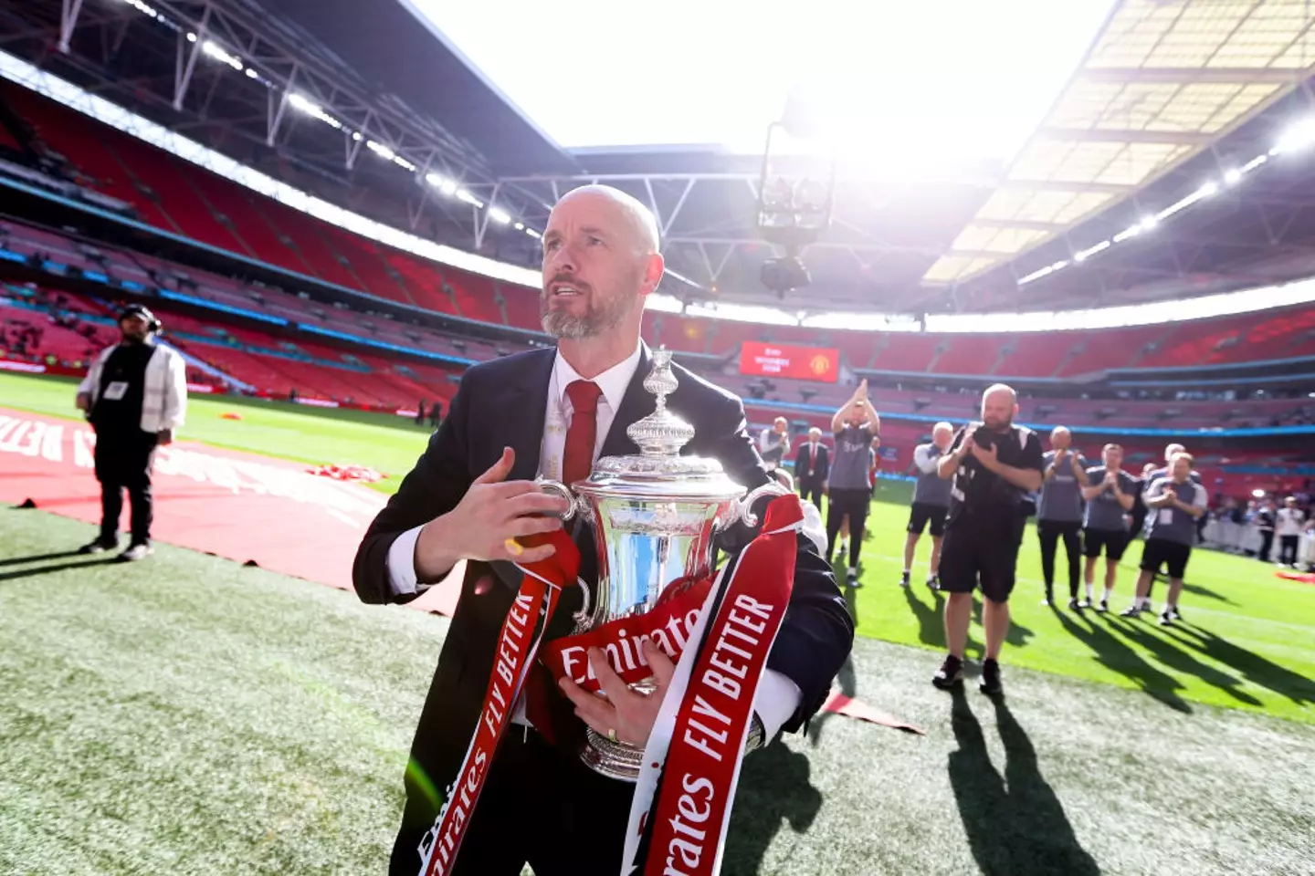 Man Utd manager Erik ten Hag celebrates while holding the FA Cup trophy (
