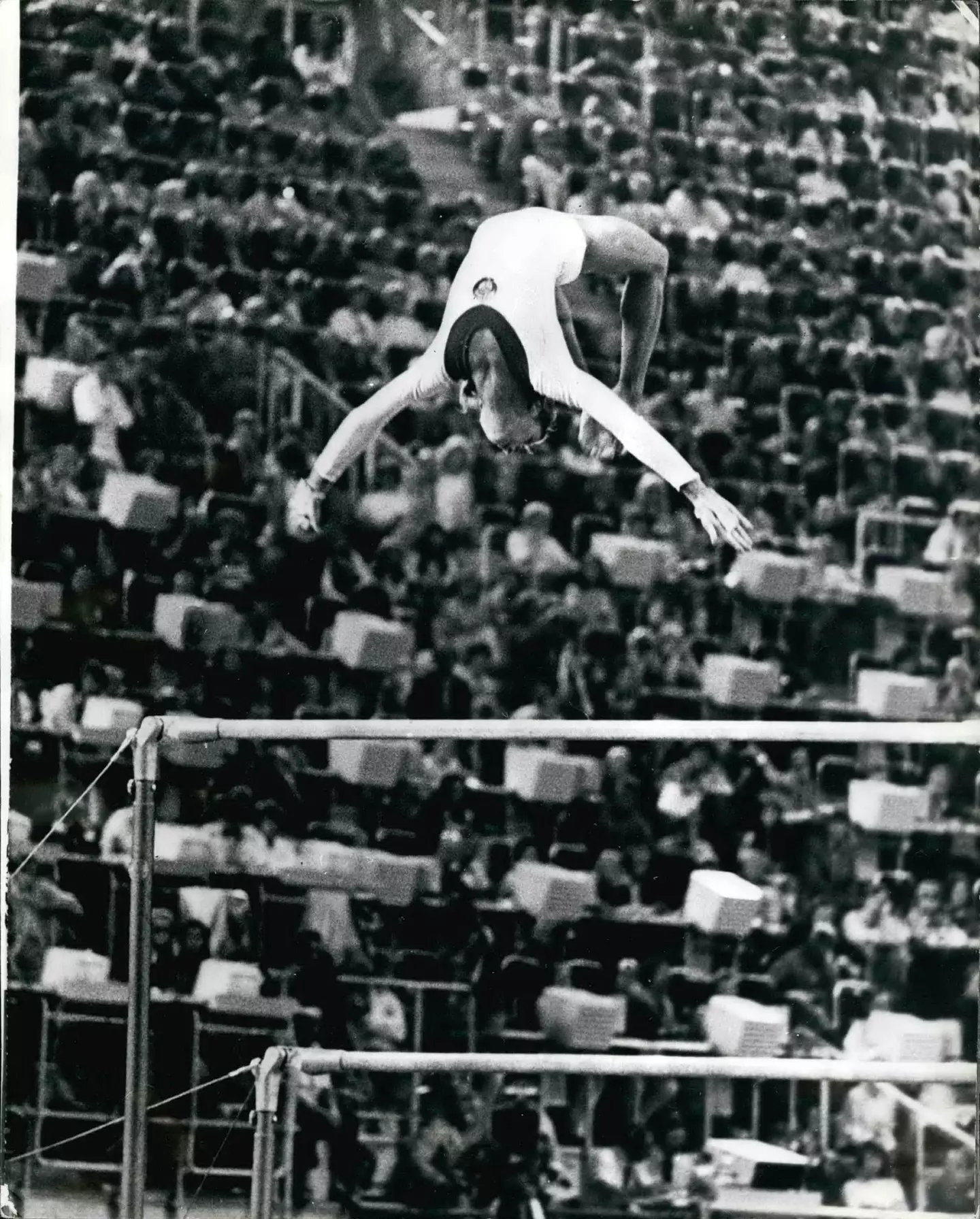 Olga Korbut performing the now banned 'dead loop', which involves doing a backflip off the top bar and grabbing onto it.