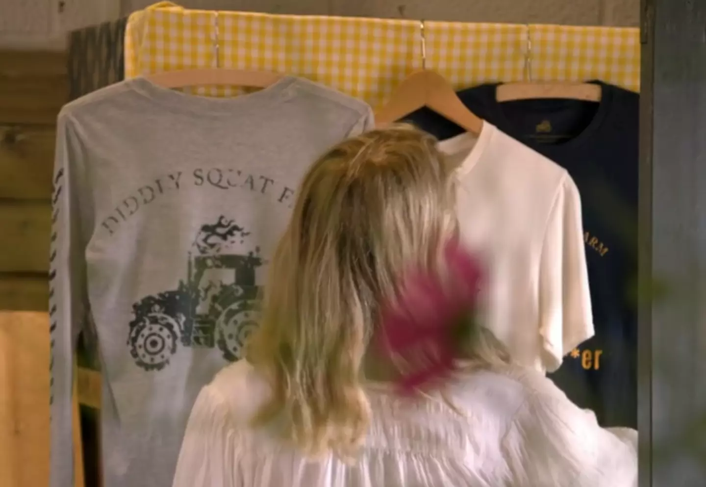 Lisa taking the price signs off of the t-shirts. (Prime Video)
