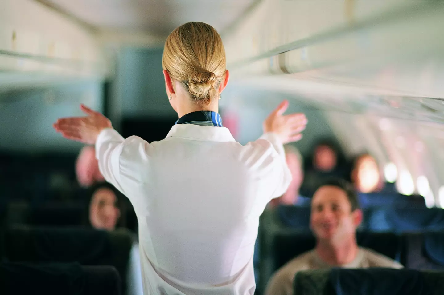 A flight attendant has revealed why cabin crew sit on their hands during takeoff and landing. (Getty Stock Image)