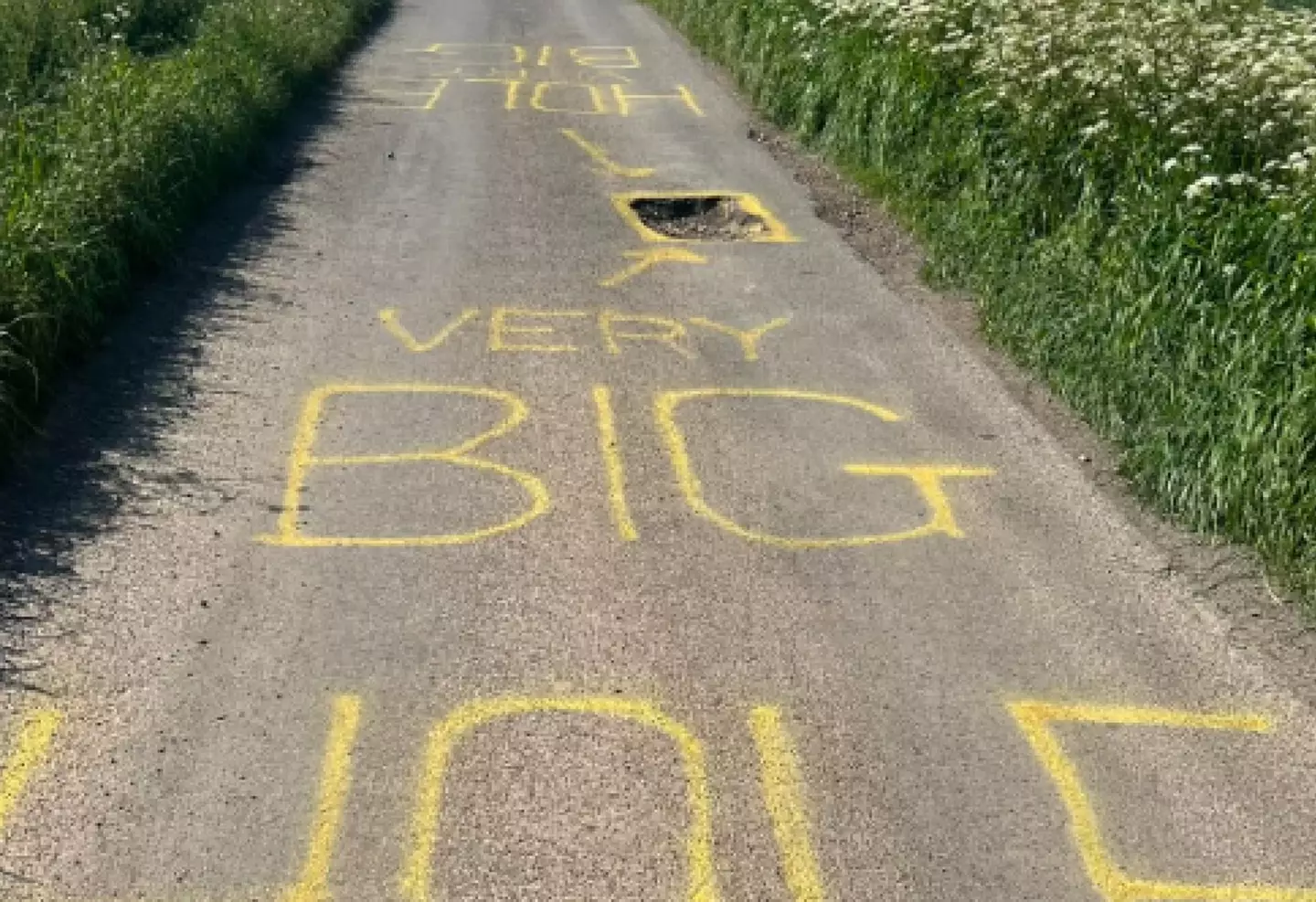 Some mystery 'artist' is helpfully pointing out the pothole to motorists.