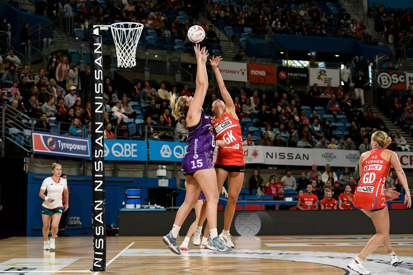 Donnell Wallam of the Queensland Firebirds and Sarah Klau of the Swifts compete for the high pass.