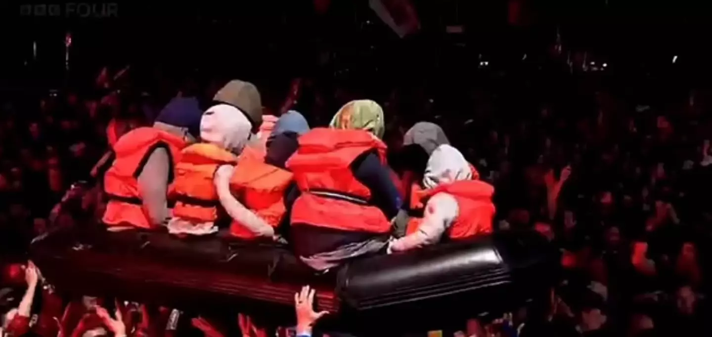 An inflatable life raft filled with dummy migrants surfed the crowd during the Idles set (BBC)