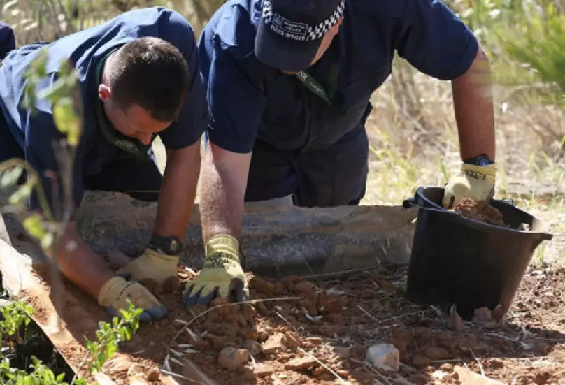 British police conduct a finger-tip search of an area of scrubland close to where Madeleine McCann went missing.
