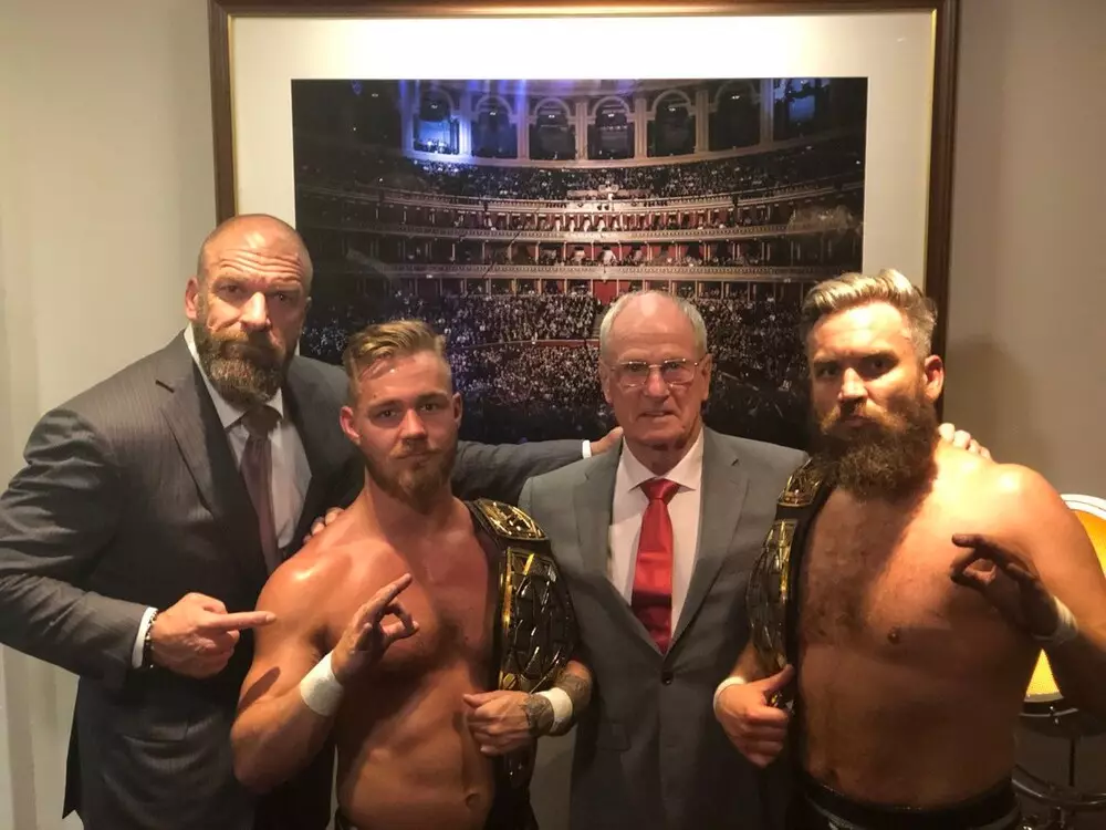 Trent Seven (Far R) and tag team partner Tyler Bate (L) with Triple H and Johnny Saint. (Image
