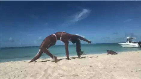Couple practicing yoga is struck by waves