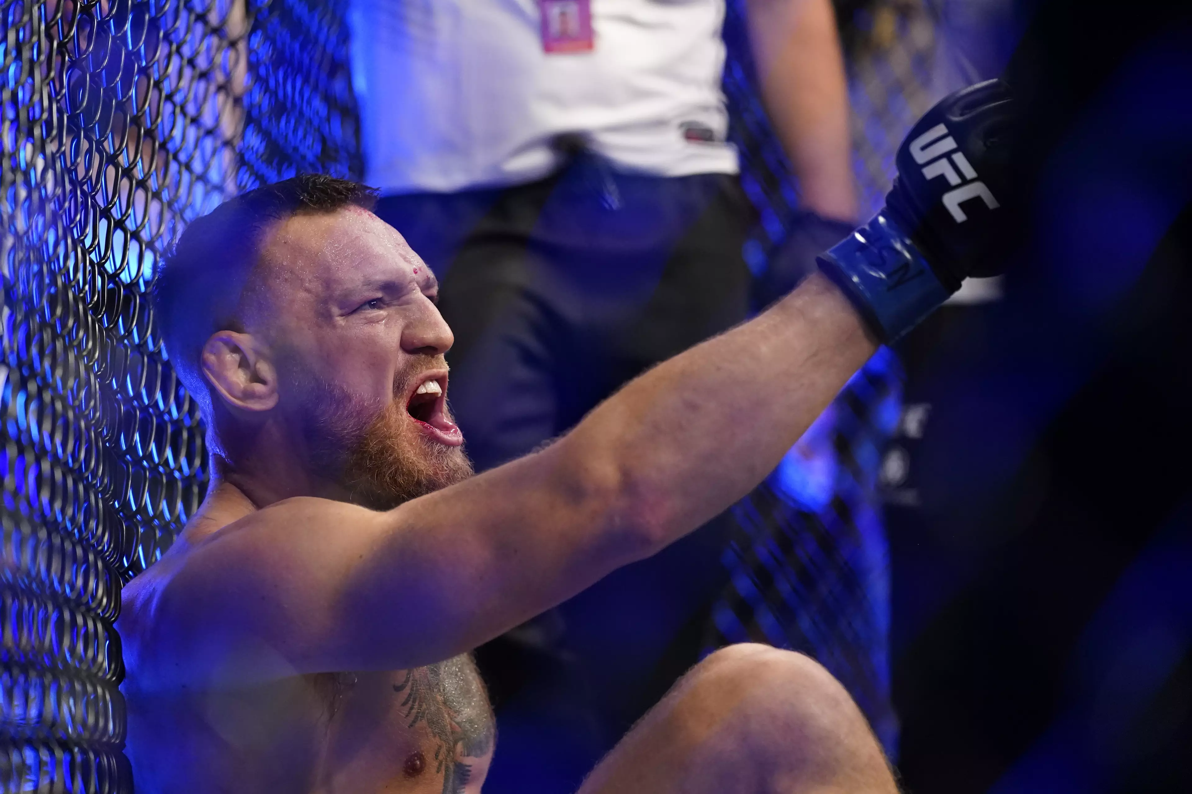 McGregor shouts at Poirier whilst sitting with his broken leg. Image: PA Images