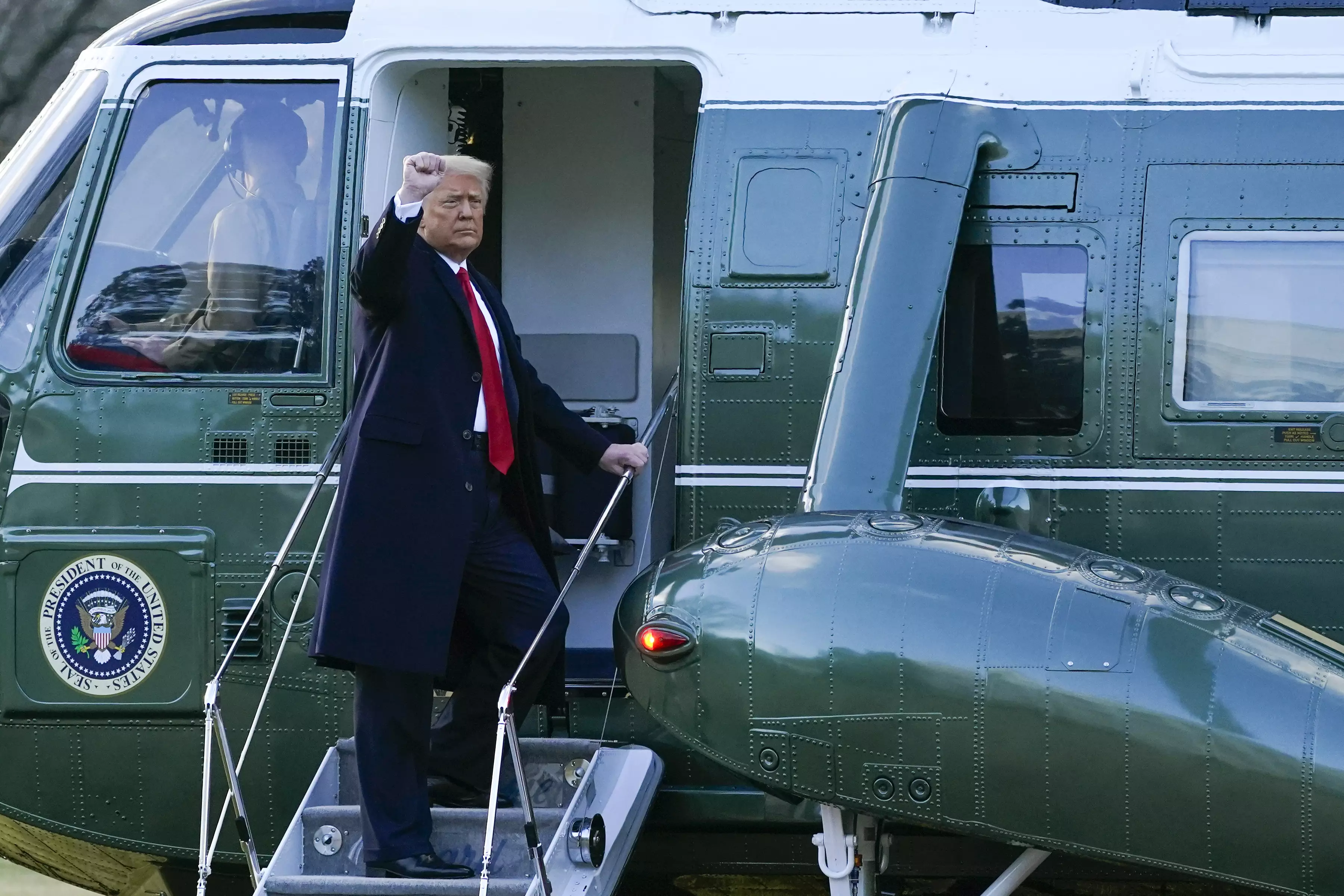 rump gestures as he boards Marine One on the South Lawn of the White House on January 20, 2021.