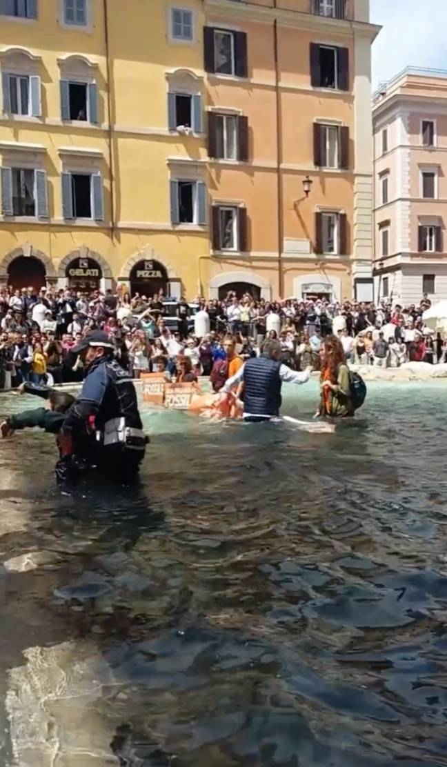 Climate activists jump into Rome's Trevi Fountain and dye the water black