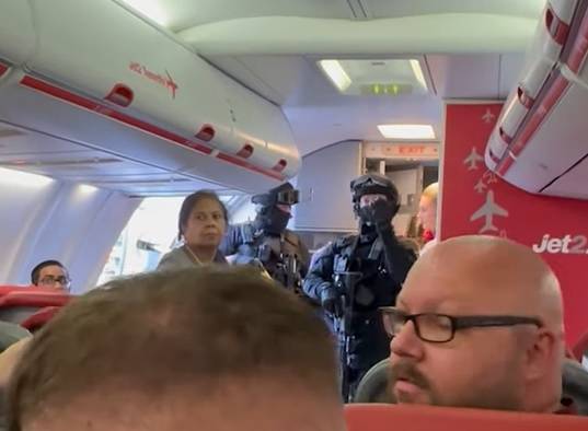 武装警察登上飞机，要求与他们一起休假。图片来源：菲利普·洛（Philip Lowe）通过故事