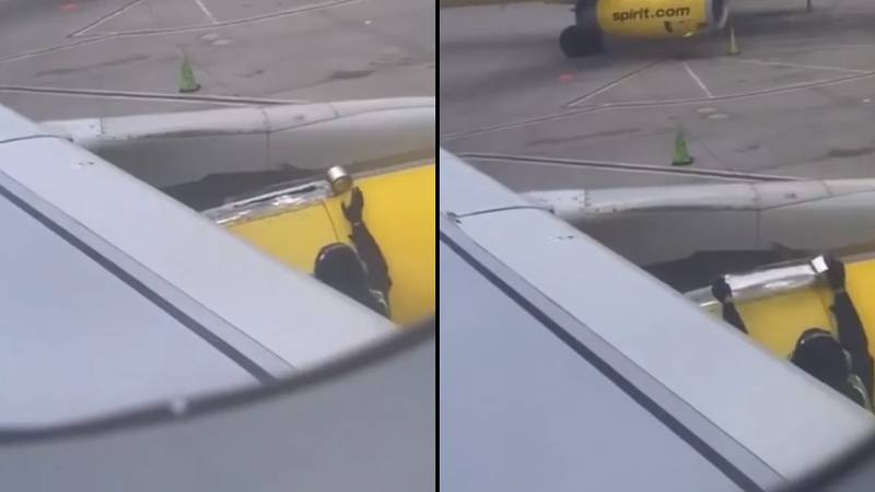 震惊的航空公司乘客手表工人在起飞前将胶带放在飞机翼上