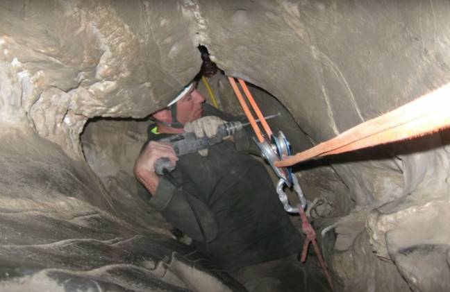 一名救援人员试图从洞穴中解脱琼斯。图片来源：YouTube /引人入胜的恐怖