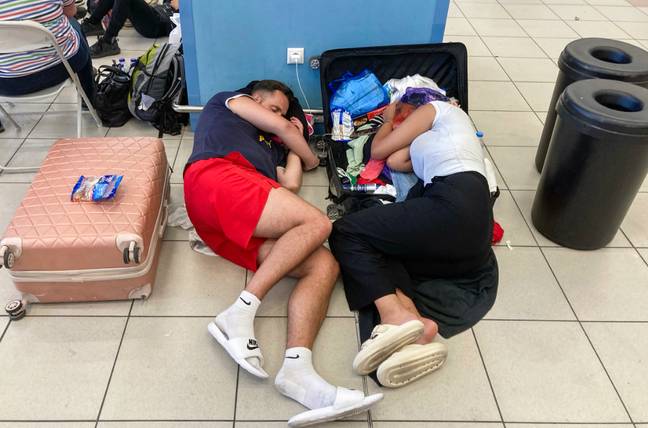 游客一直在体育馆的地板上睡觉。信用：将通过盖蒂图像Vassilopoulos/AFP