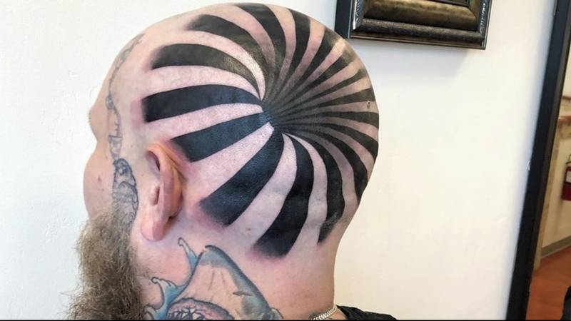 男人的“光学错觉”纹身看起来他的秃头有一个巨大的孔