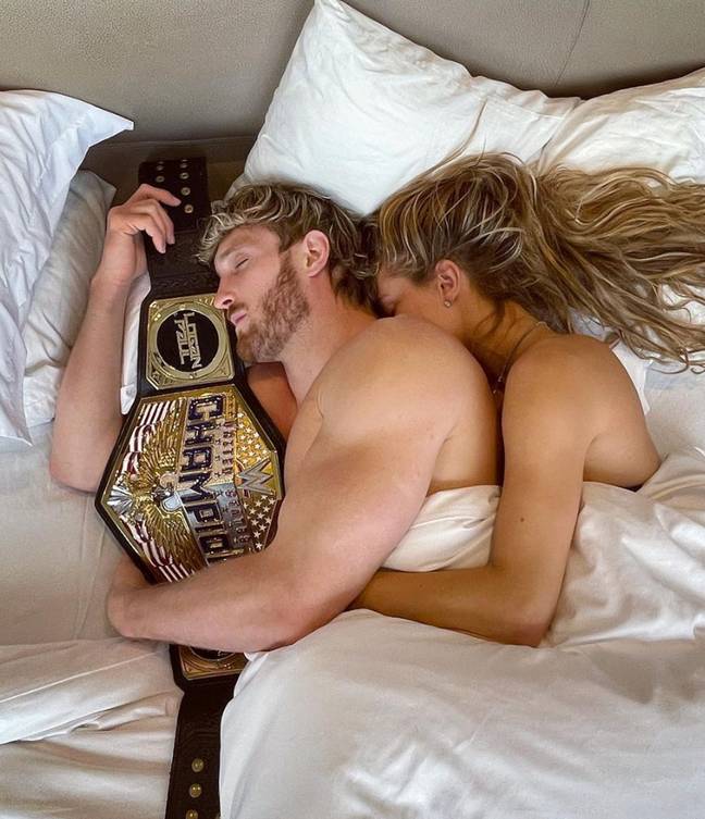 Paul holding the United States Championship in bed alongside fiancee Nina Agdal. (Image Credit: Logan Paul/Instagram)