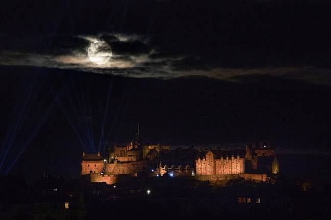 The Sturgeon Moon through the clouds at Edinburgh Castle. Credit: Alamy / PA Images