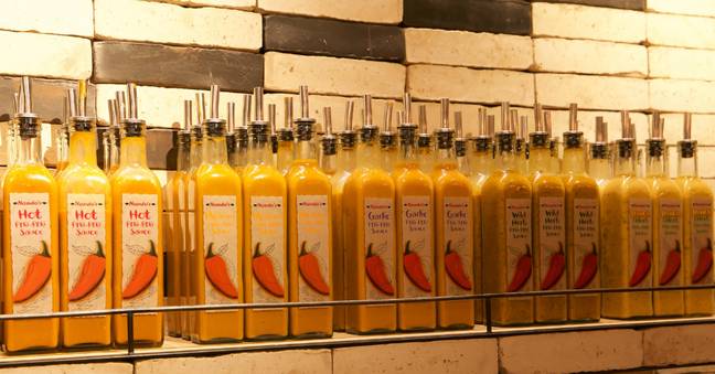 People are divided over the best way to get Nando's sauce out of the bottle. (Credit: Alamy)