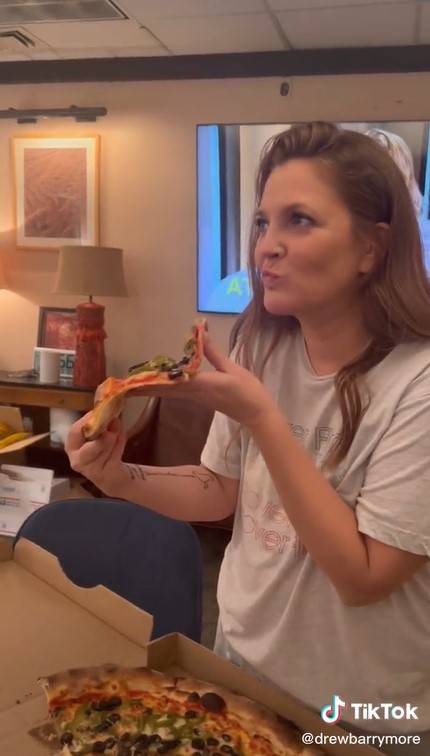 The joy of pizza is too hard to resist and Drew takes a bite anyway. Credit: @drewbarrymore / Tiktok