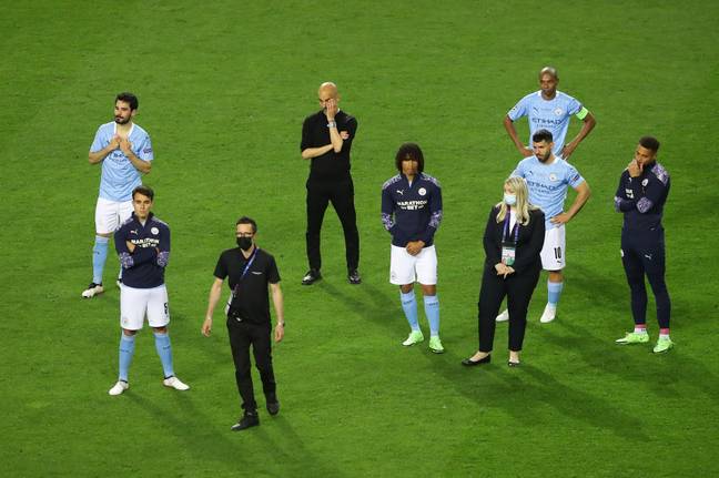 Guardiola and City players look on as Chelsea lift the trophy last year. Image: PA Images