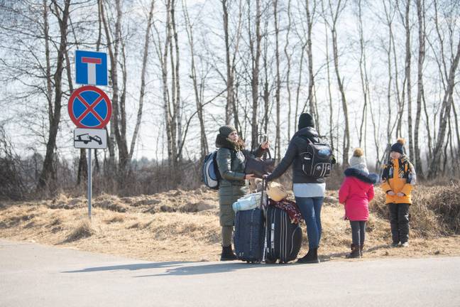 Oxana (l) and Maria, as well as their children, are fleeing from the village of Shklo near Yavoriv, stand at the Budomierz border crossing between Ukraine and Poland. Credit: Sebastian Gollnow/dpa/Alamy Live News