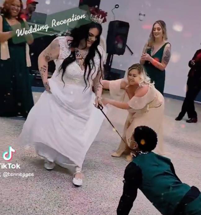 A bride received criticism for holding her husband on a lead. Credit: @tenneggee/TikTok
