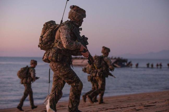 A group of bemused fishermen noticed the 30 commandos making their way up the beach. Credit: Operation 2021/Alamy Stock Photo