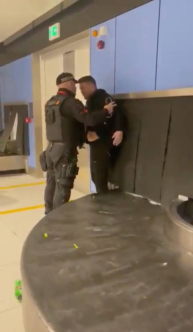 Robinson was held near a baggage carousel by the officer. Credit: Twitter