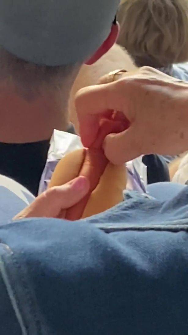 A video of a fan sat in the stands has gone viral after the woman uses a pretty bizarre method of eating a hot dog, which many of us have never witnessed before. Credit: @joshgarlepp/Twitter