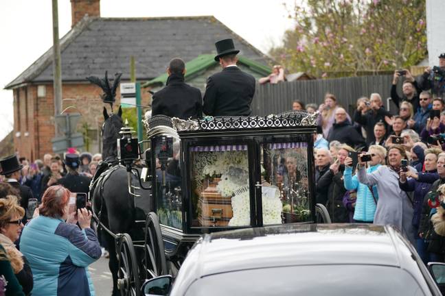 Paul O'Grady's coffin was carried by a horse drawn carriage and decorated with floral tributes to some of his beloved pets. Credit: PA Images