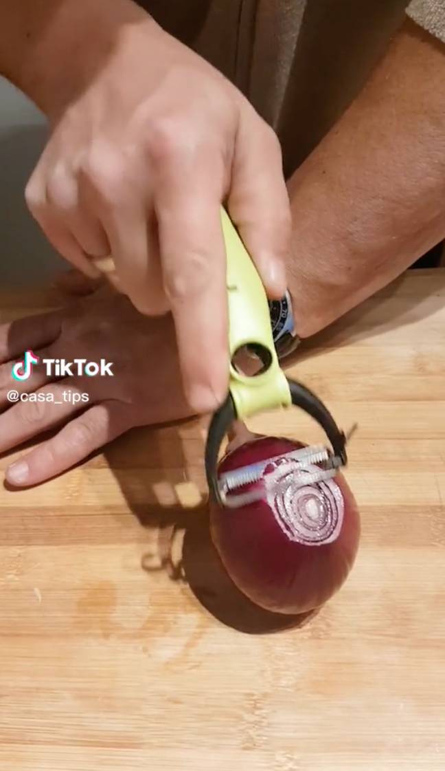 It involves spearing the onion with a fork and using a peeler to slice it. Credit: Credit: TikTok/@casa_tips