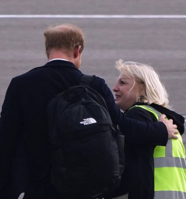 A airport staff member appears to console Prince Harry as he leaves for London on Friday morning. Credit: PA