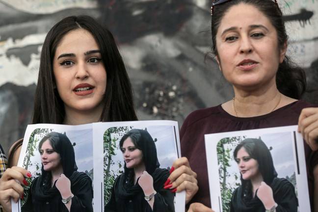 Kurdish women holding pictures of Mahasa Amini, the 22-year-old who died in police custody. Credit: dpa picture alliance / Alamy 