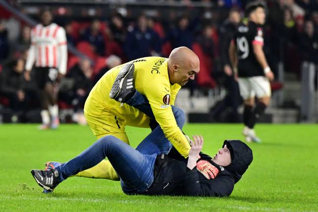 Dmitrovic pins down the pitch invader. Image: Alamy
