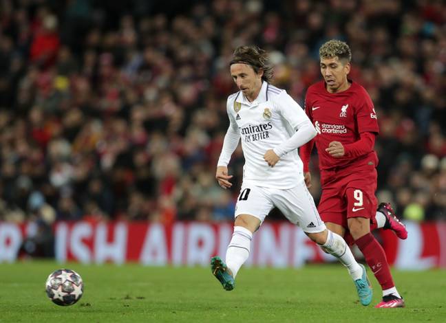 Modric under pressure from Roberto Firmino during the game. (Image Credit: Alamy)