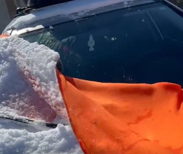 Peeling the blanket away showed it had stopped any ice growing on the windscreen. Credit: TikTok/@nicolebweb