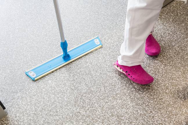 Cleaner mopping a hospital ward floor. Credit: Phanie / Alamy 